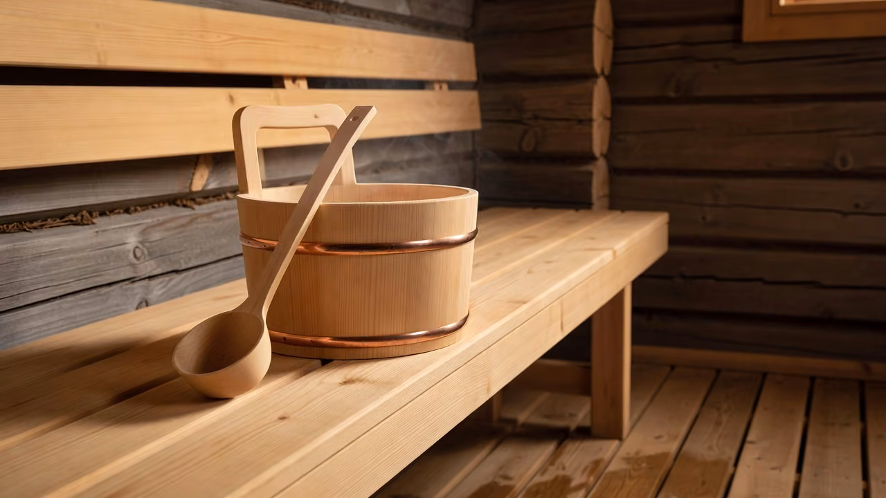Traditional wooden sauna bucket and ladle on a sauna bench